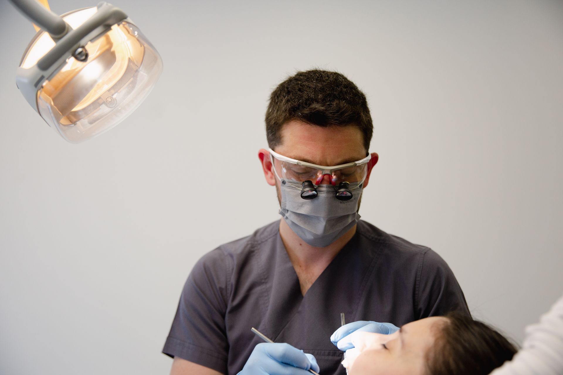 Endodontist using magnification loupes during root canal procedure