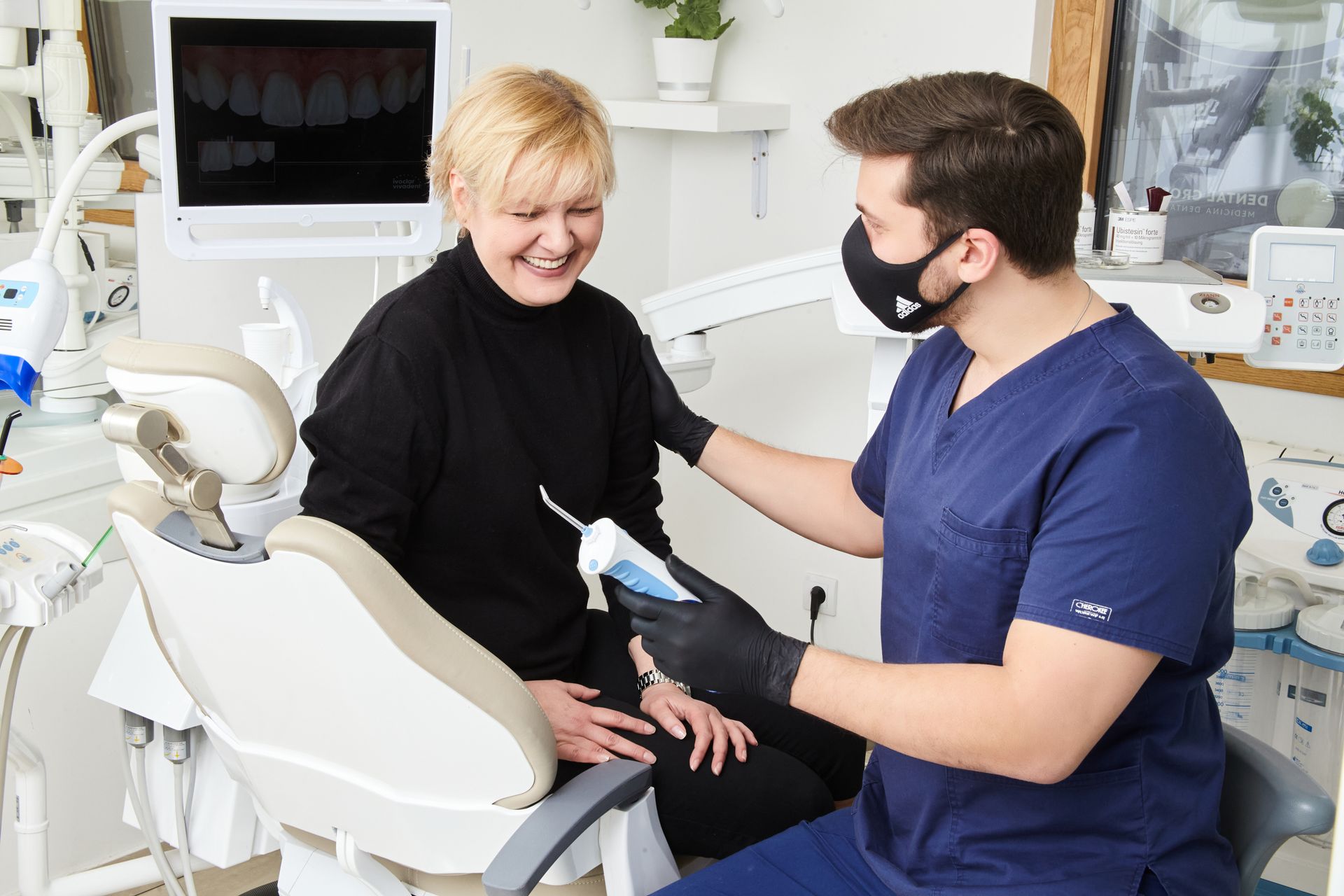 Endodontist explaining root canal treatment to smiling patient