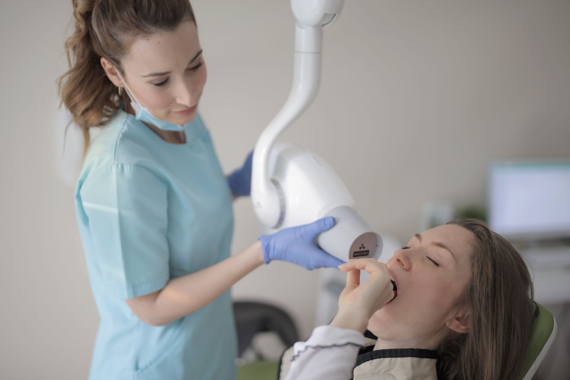 Dental assistant positioning X-ray for endodontic patient