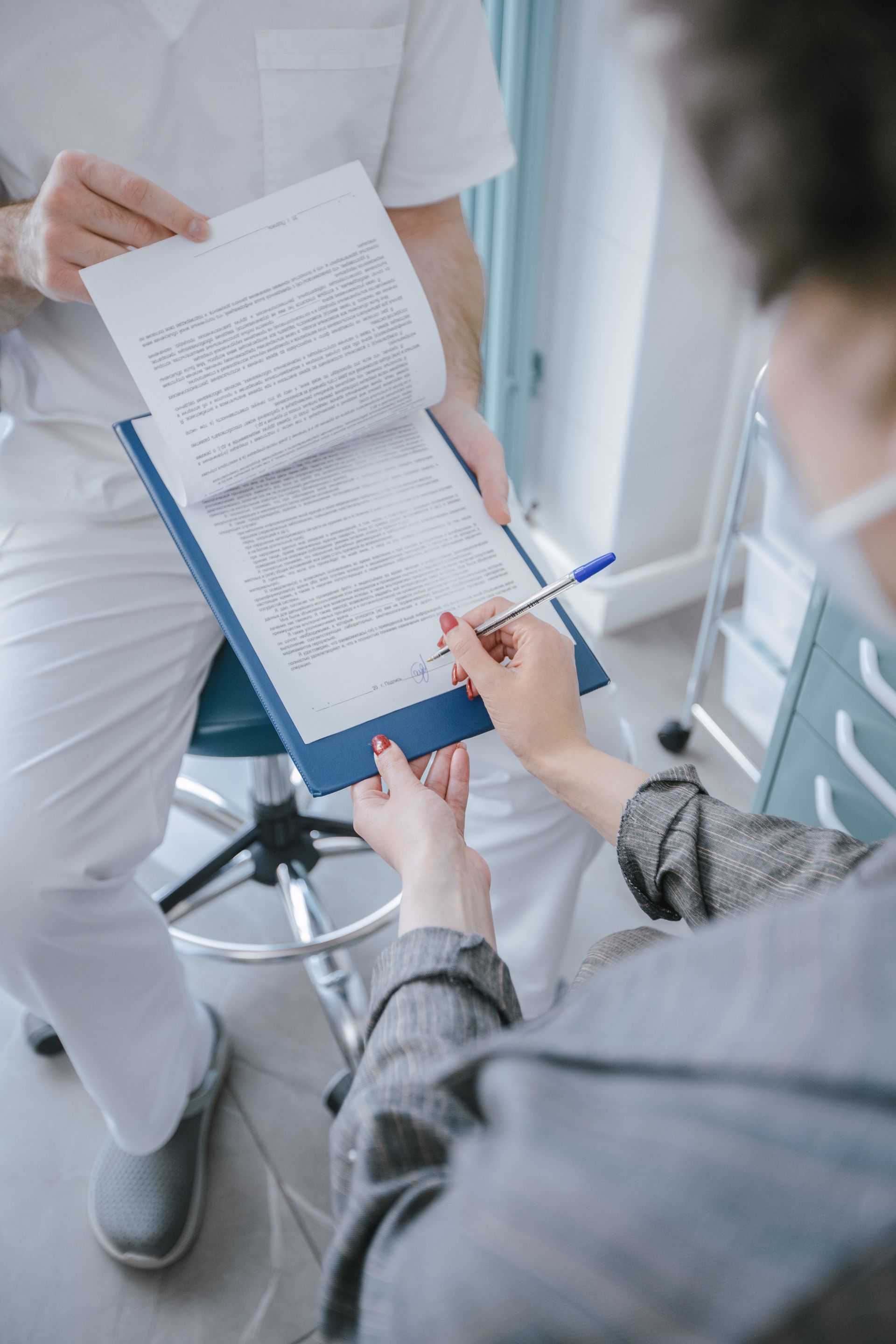 Patient signing dental consent forms before endodontic visit